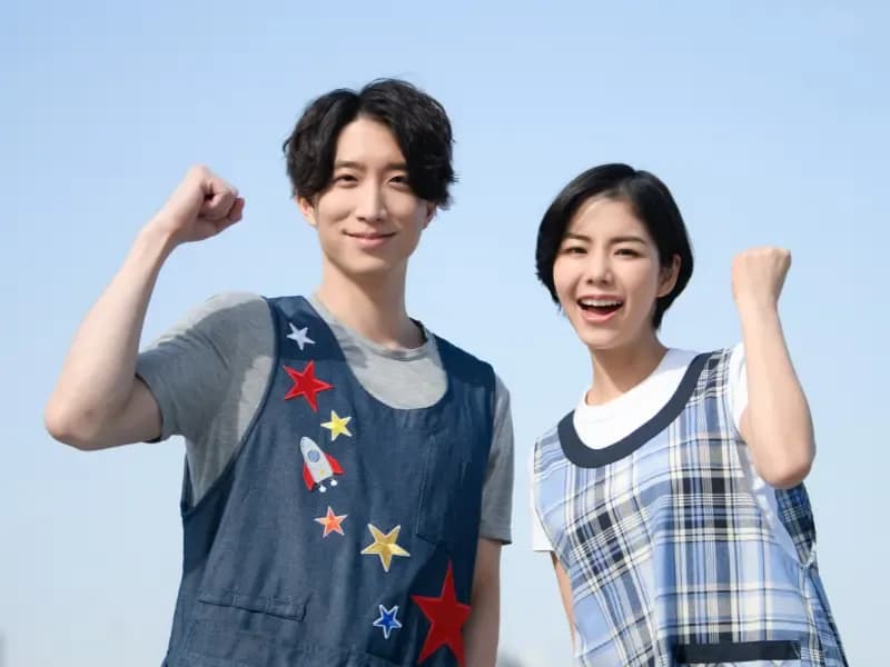 ガッツポーズをする男女の保育士の画像