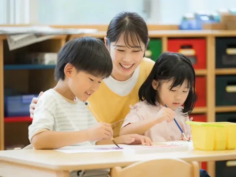 学童や放課後デイサービス等で勉強をする先生と生徒の画像