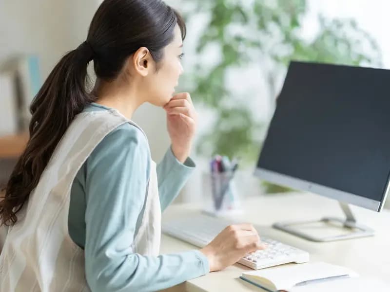PCを見つめる保育士のイメージ