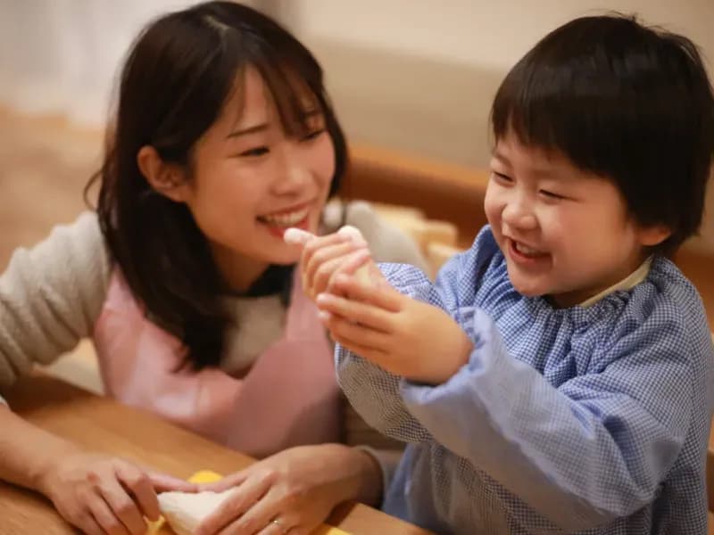 ねんどで遊ぶ男の子と保育士の画像