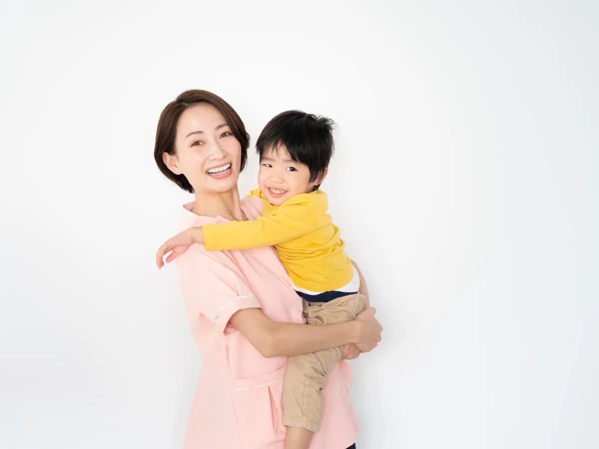 男の子を抱っこする保育士のイメージ