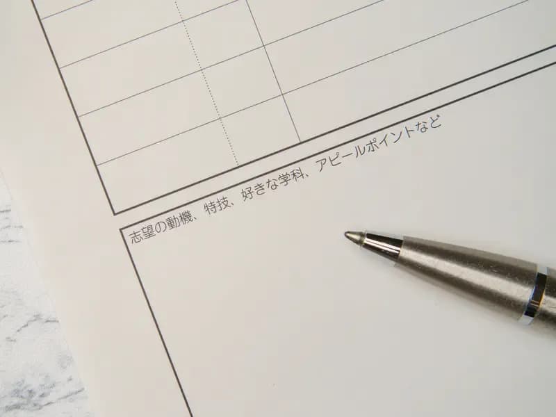 履歴書の志望動機の欄とペンの画像