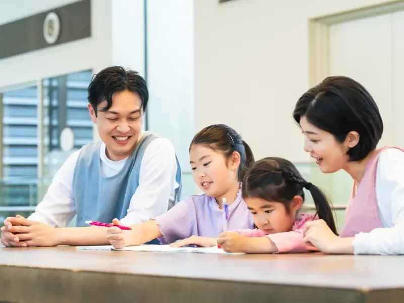 勉強する子供たちと見守る学童指導員のイメージ
