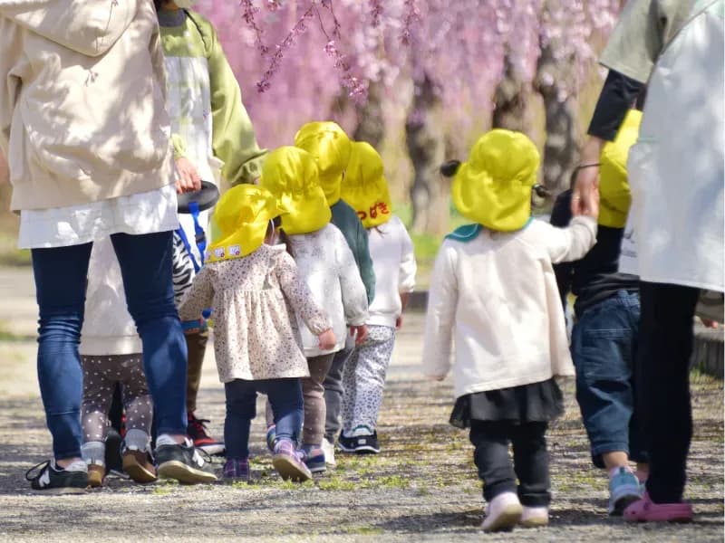 保育士とお散歩をする園児たちの画像