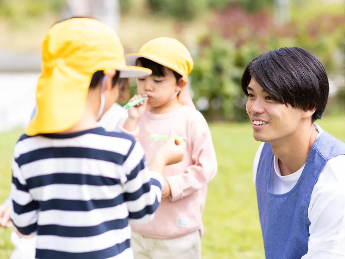 公園で遊ぶ保育士と園児の画像