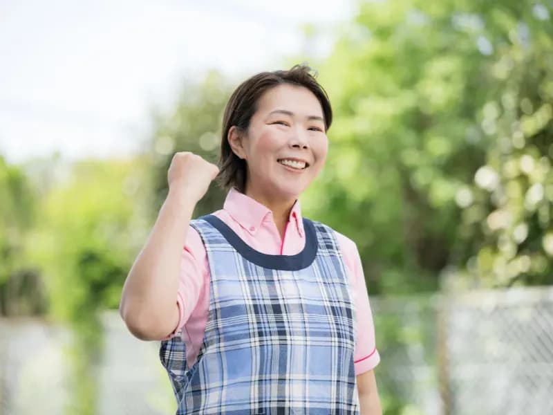 ガッツポーズをする年配の保育士の画像