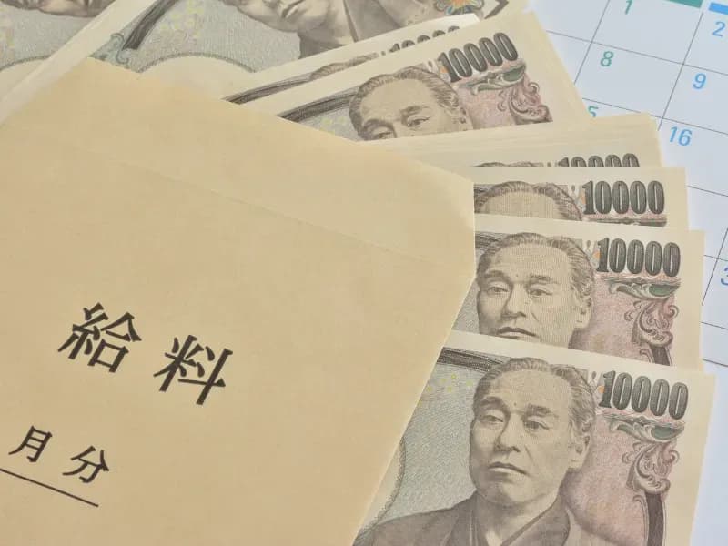 給料袋と複数の一万円札の画像