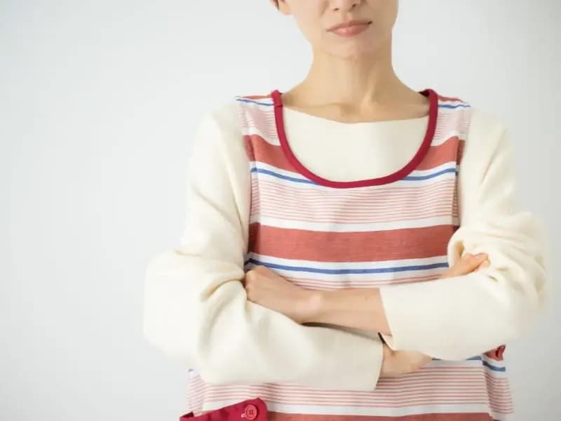 腕を組み悩んでいる保育士のイメージ