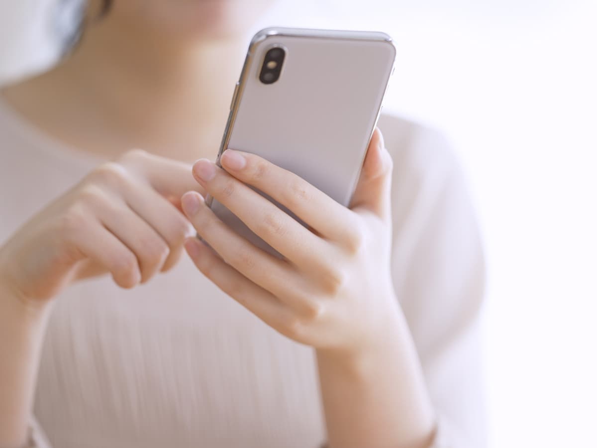 スマホを持つ若い女性の手元の画像