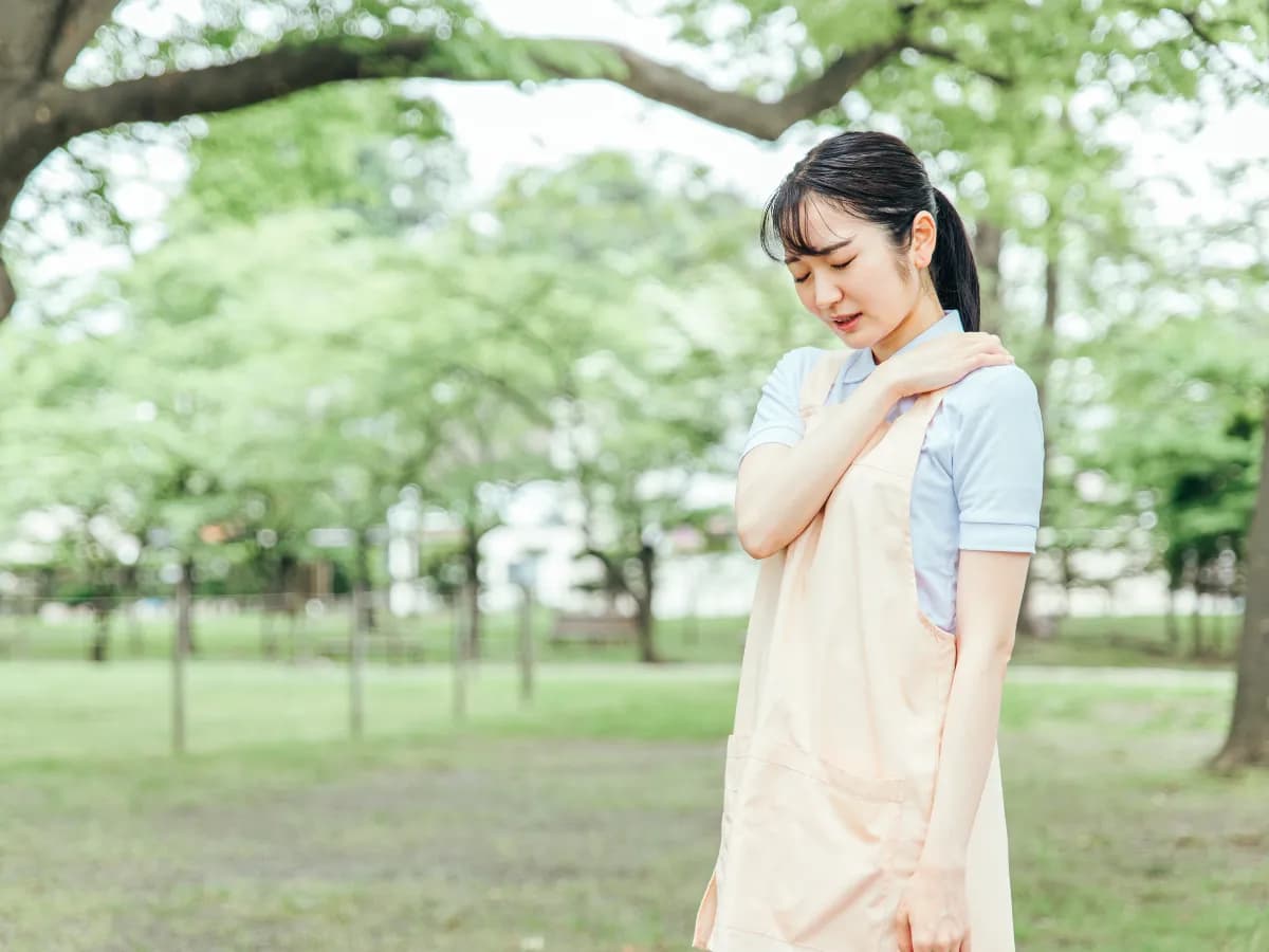 公園で疲れを感じている保育士のイメージ