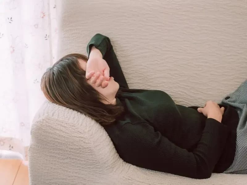 ソファでぐったりする女性のイメージ