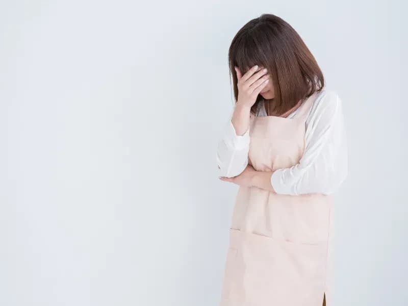 顔を隠して泣く保育士の画像