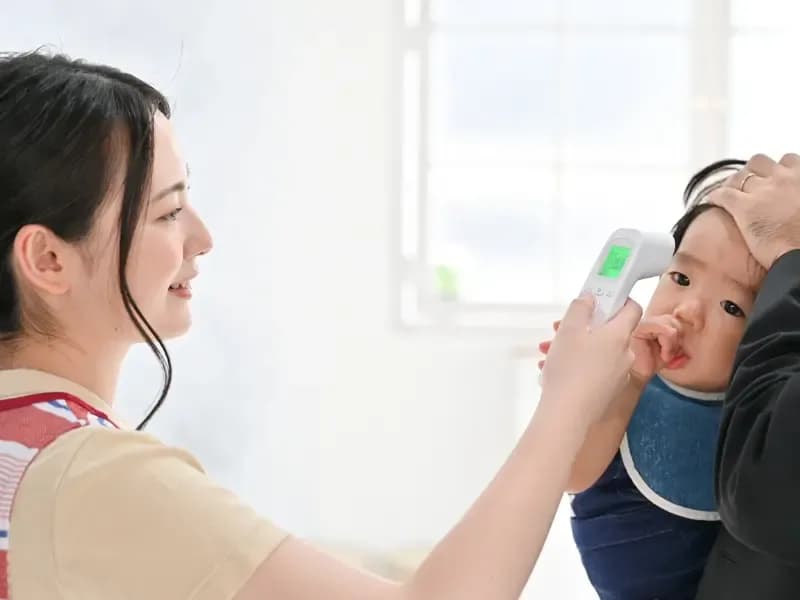 体温計で検温される赤ちゃんのイメージ