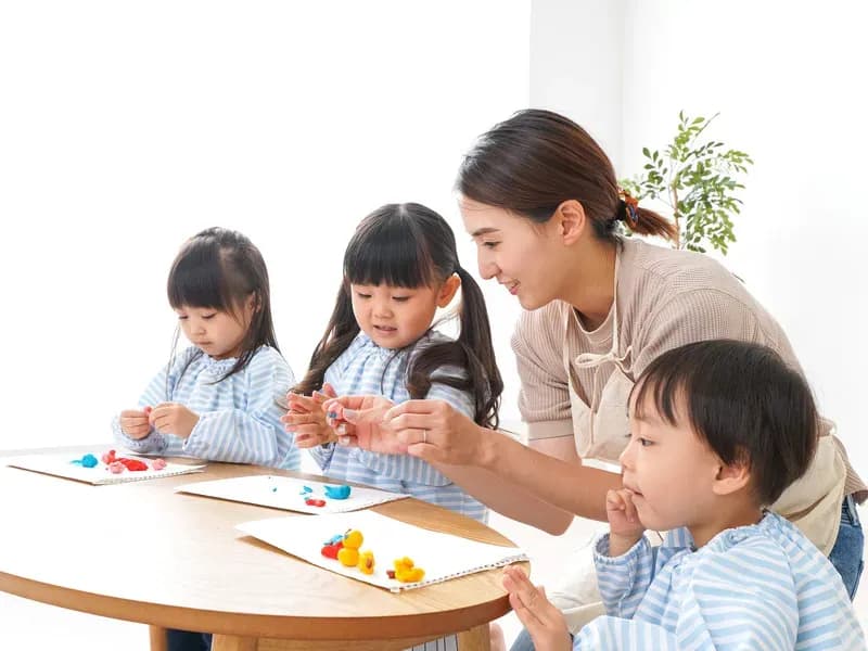 園児に囲まれる幼稚園の先生