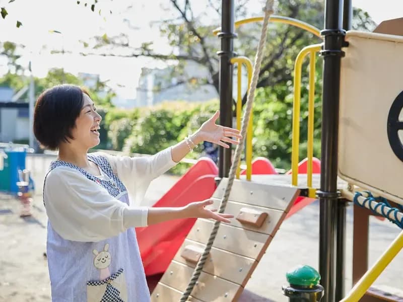 公園で遊ぶベテラン保育士のイメージ