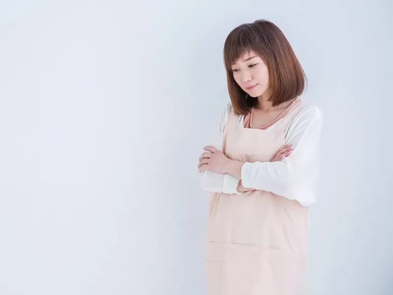 落ち込むエプロン姿の女性のイメージ