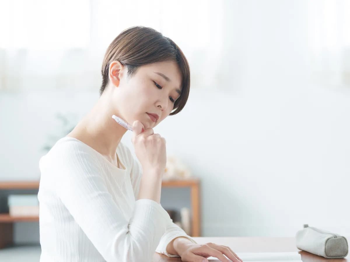 書き方に悩んでいる女性のイメージ