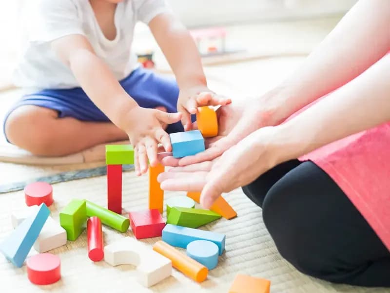 積木で遊ぶ子供と保育士のイメージ