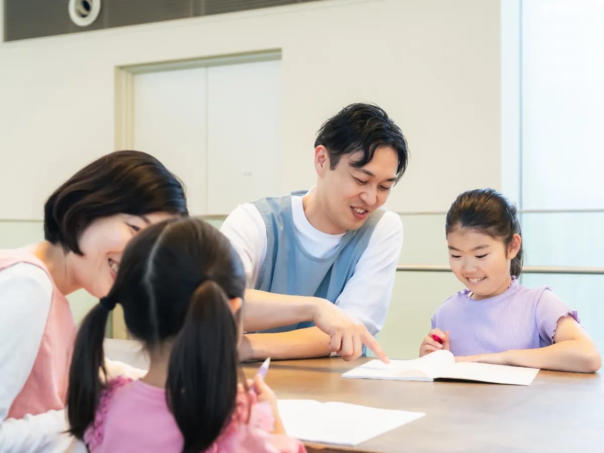 1対1で子供に寄り添う二人の保育士の画像