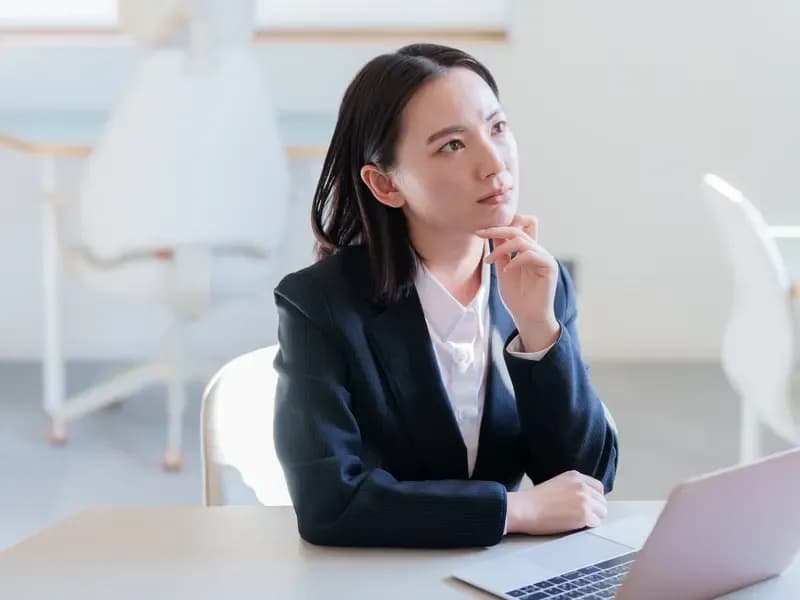 ノートパソコンを使って志望動機を考える若い女性のイメージ