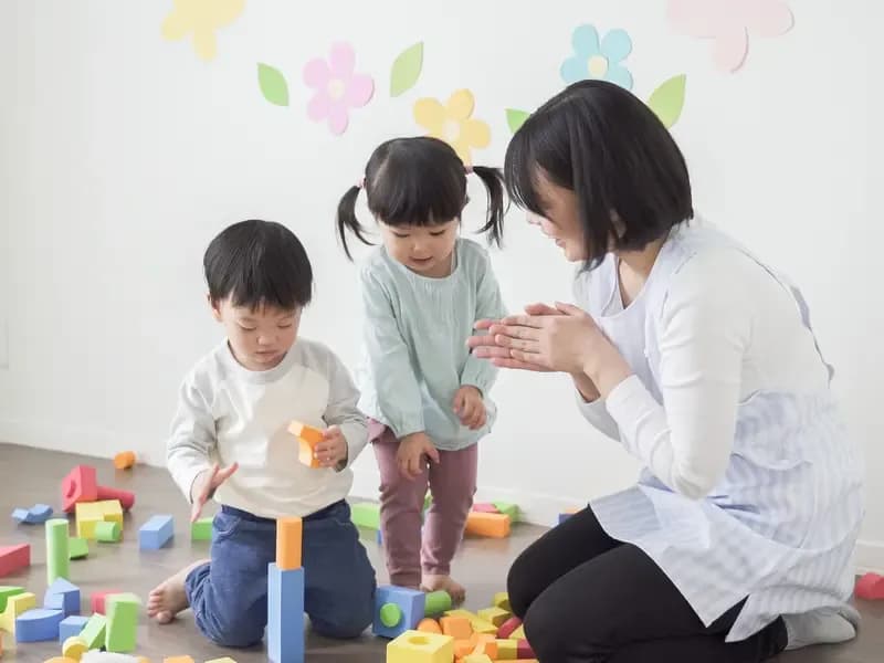 積木で遊ぶ保育園児と保育士のイメージ