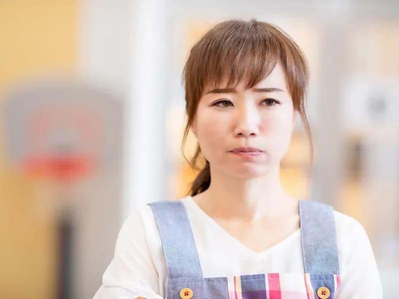 不満げな顔をする保育士の画像