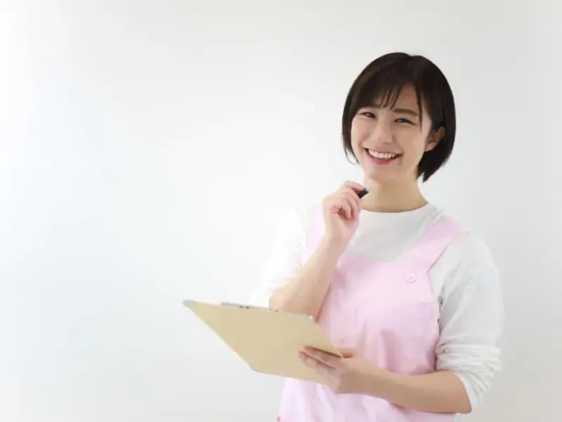 ボードとペンを持つ笑顔の保育士のイメージ