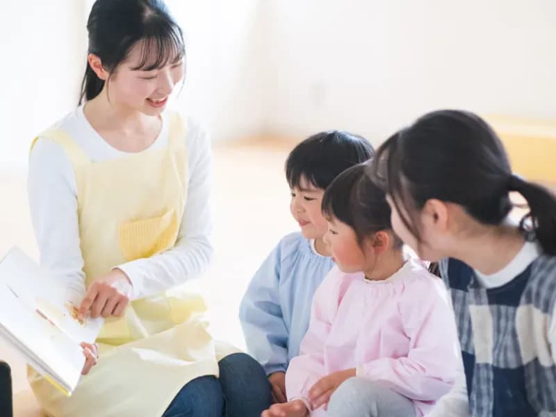 読み聞かせをする保育士の画像