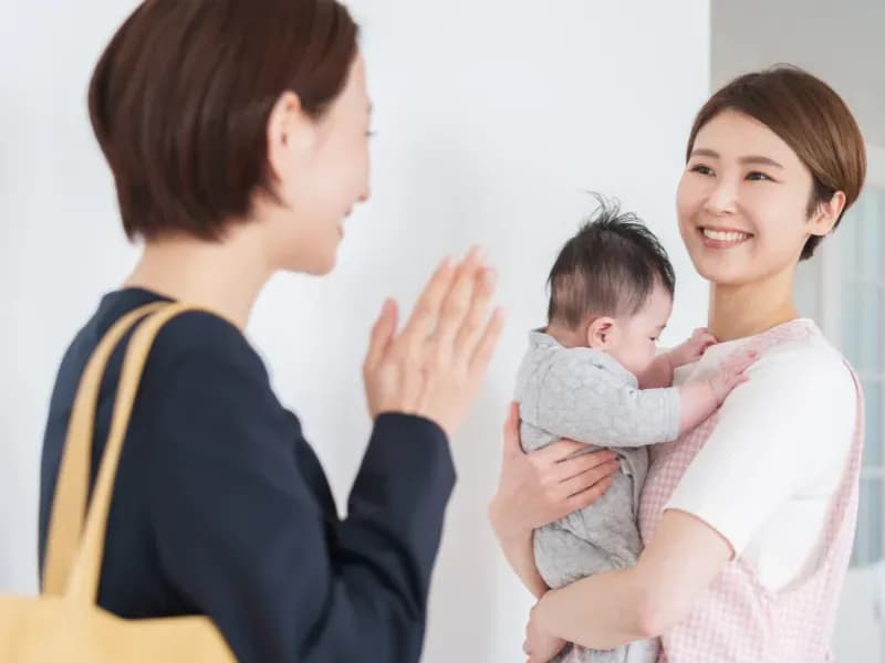 園児を保護者から預かる保育士の画像