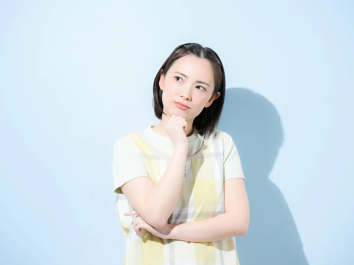 悩んでいる保育士の女性の画像