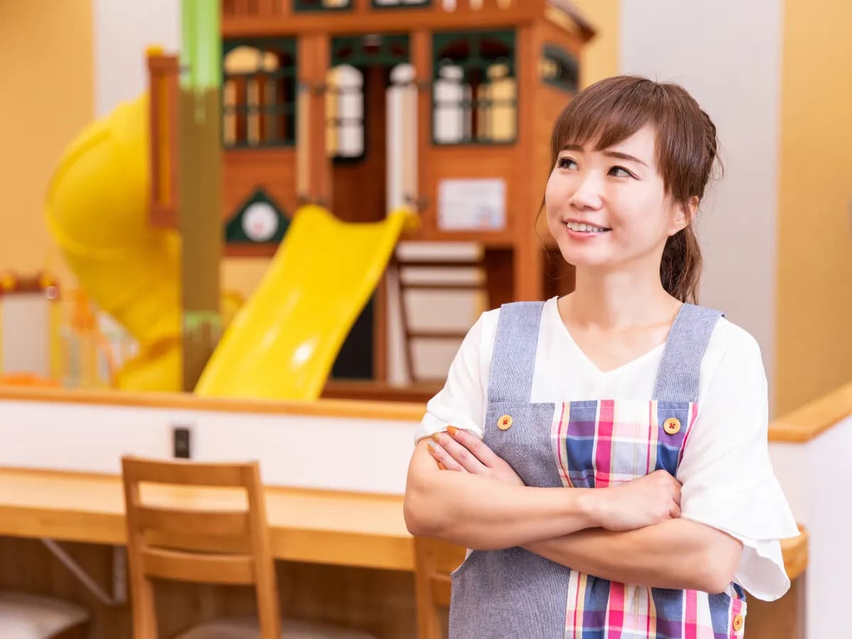 腕を組んで考えいる保育士のイメージ