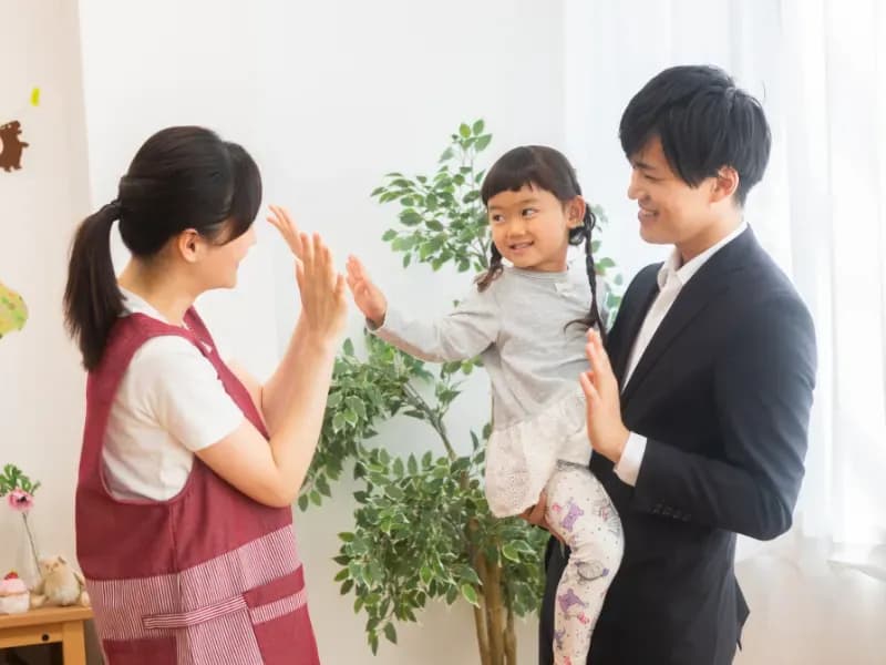 お迎えに来た保護者と保育士の画像