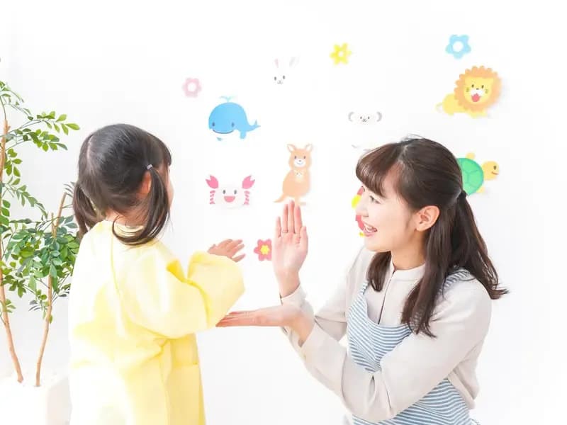 保育士が園児と手遊びしている様子