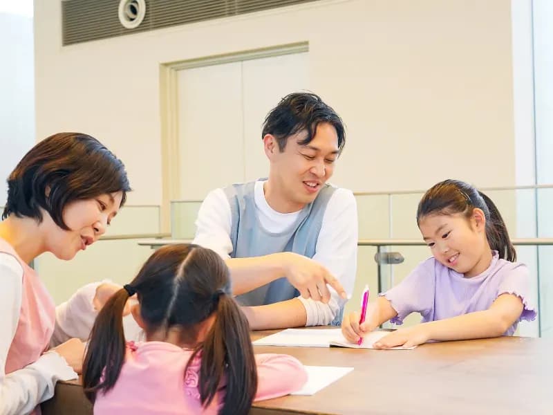 子供に勉強を教えてる保育士のイメージ