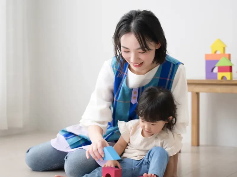 積み木で遊ぶ子供と保育士のイメージ