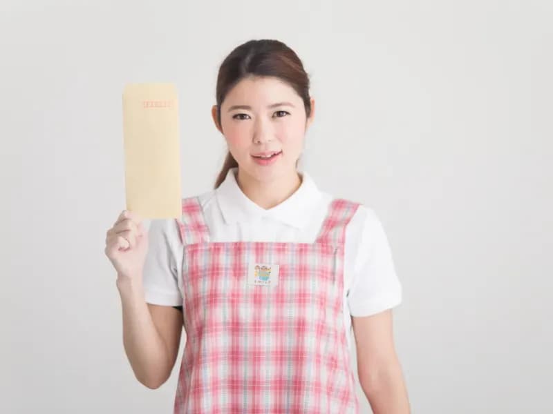 封筒を持っている保育士