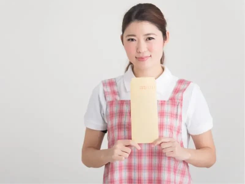 給料袋を持った保育士のイメージ