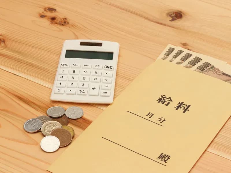 電卓と小銭と給料袋のイメージ