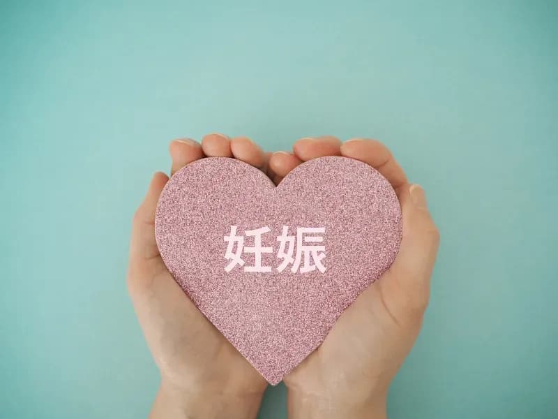 手に持ったハートに妊娠の文字のイメージ