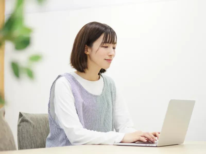 PCで仕事をする保育士の画像