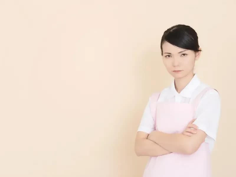 怒った顔で腕を組む保育士のイメージ