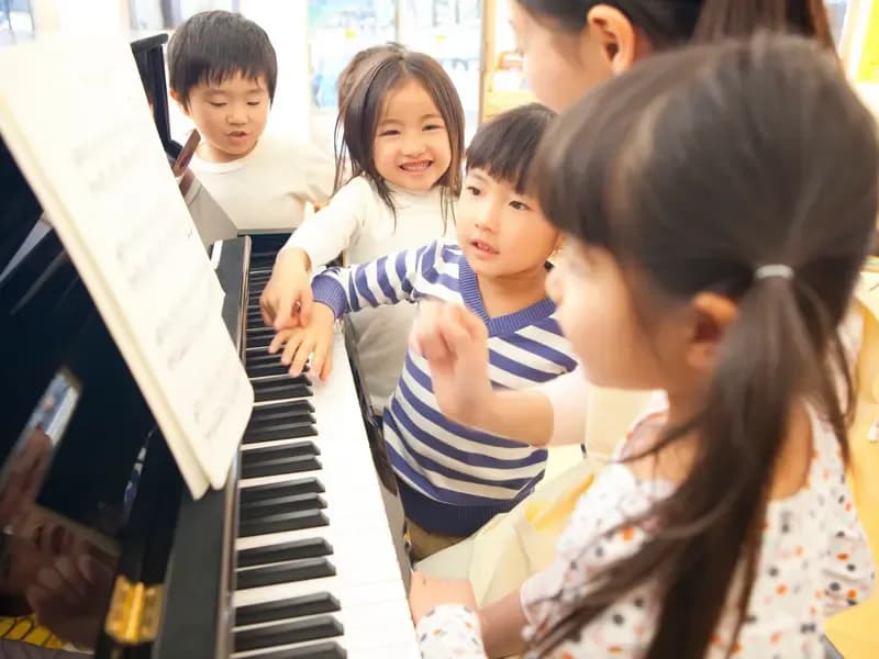 ピアノを弾く先生と歌う在園児のイメージ