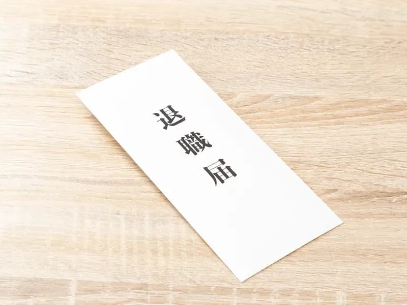 机に置かれた退職届の画像