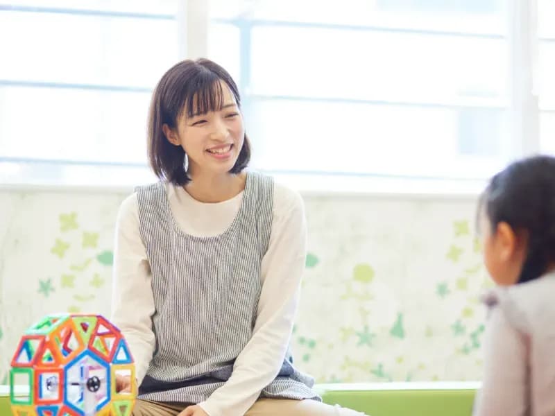 おもちゃで子供と遊ぶ保育士のイメージ