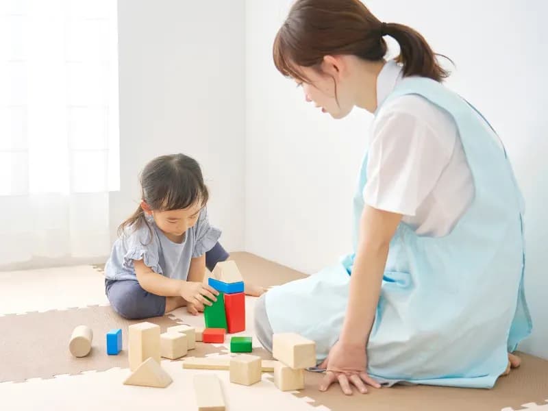 こどもと遊ぶ保育士の画像