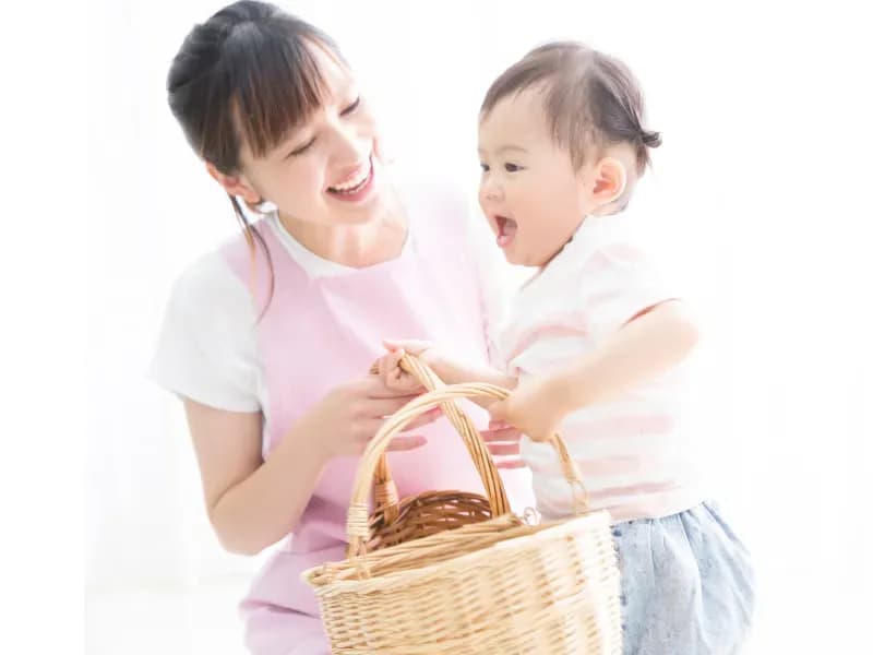 女児を見守る保育士の画像