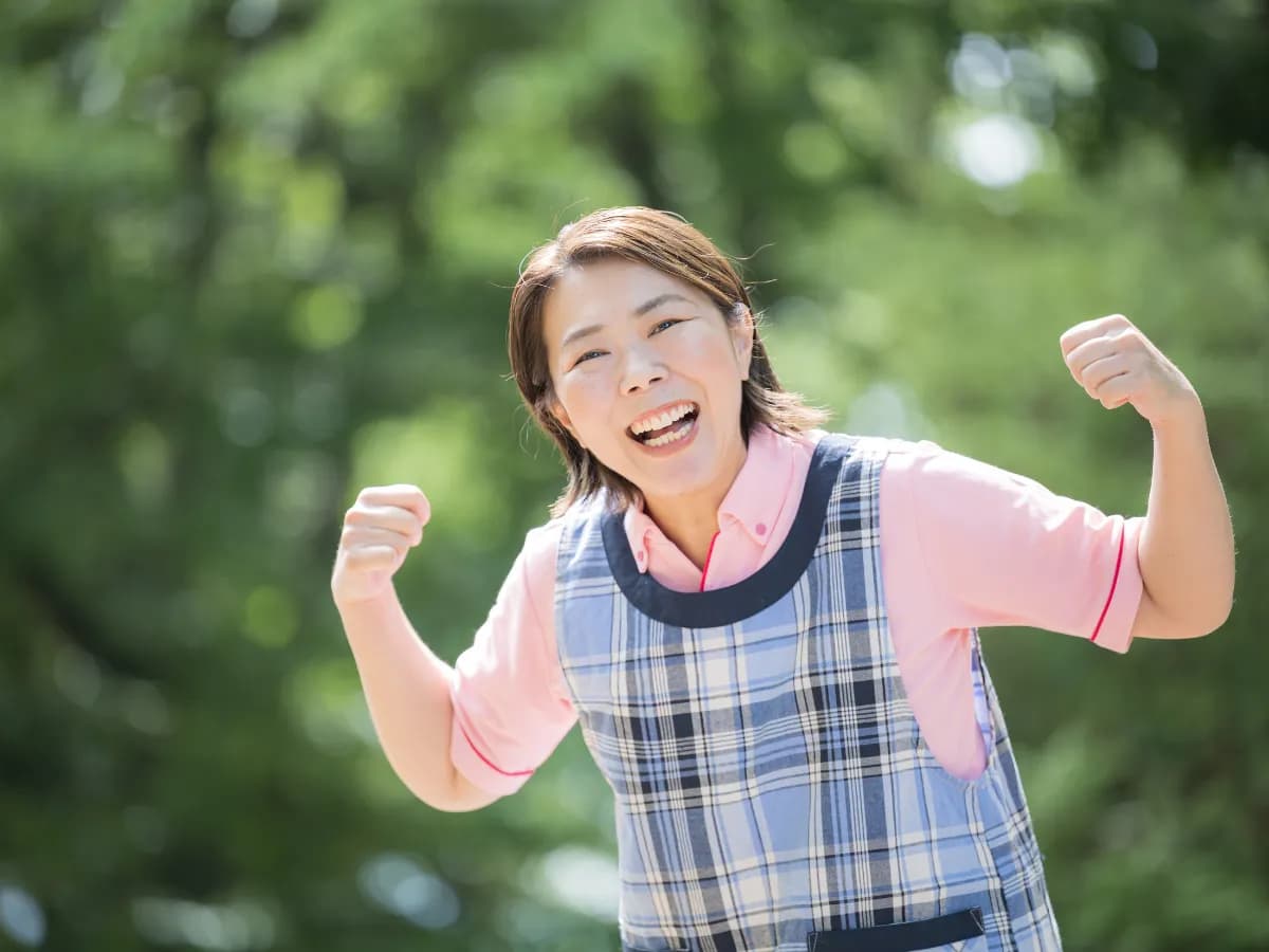 笑顔でガッツポーズをしているベテラン女性保育士のイメージ