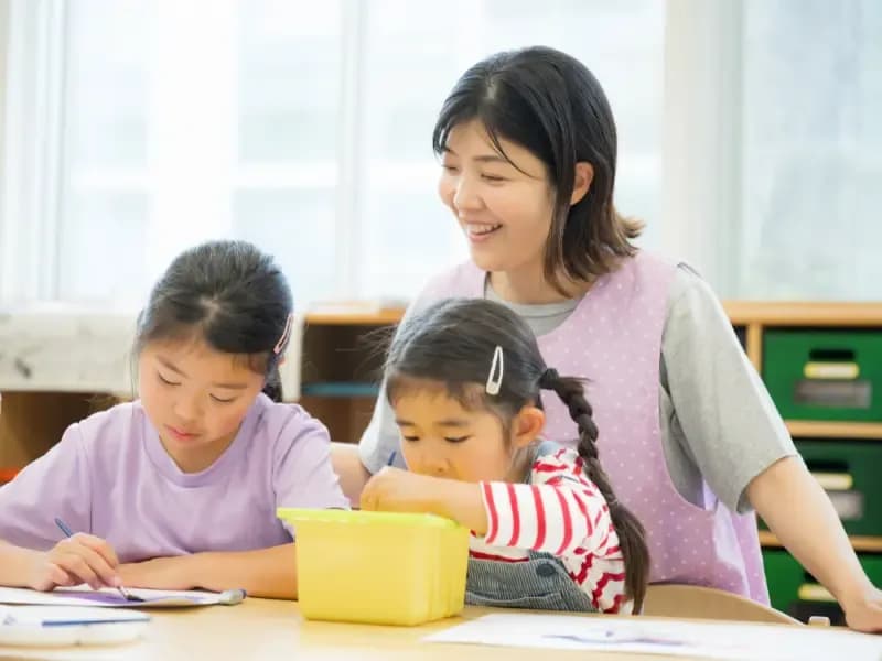 放課後デイサービス等で絵を描く勉強をする先生と生徒の画像