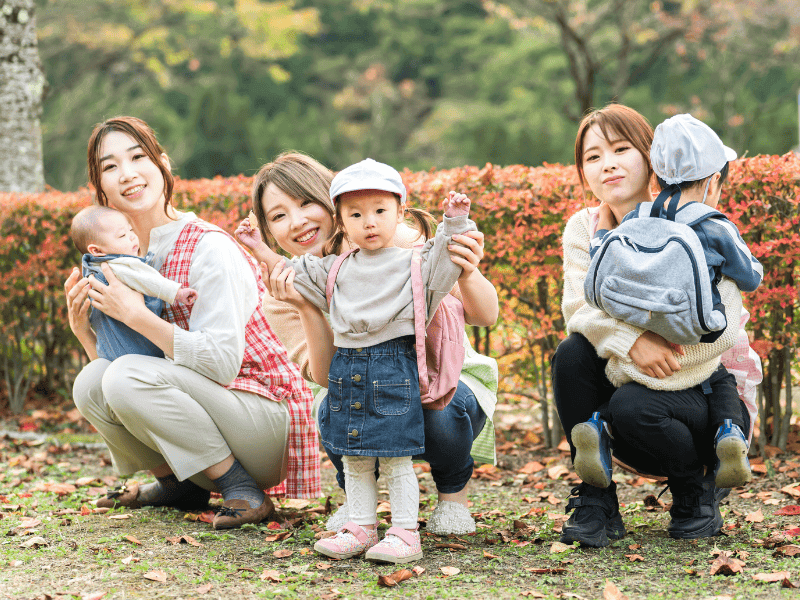 秋の遠足に行く幼児と保育士の画像
