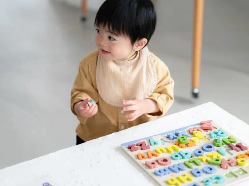 アルファベットの磁石で遊ぶ幼児の画像